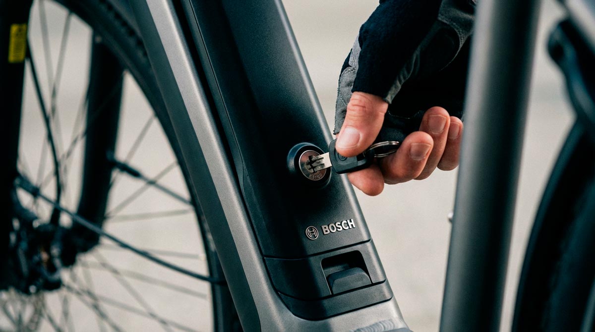 Close-up of SafeRide Steve unlocking a Bosch e bike battery pack, showing proper battery security technique